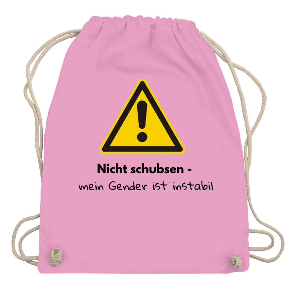 Gymbag mit großem gelben Warnzeichen mit Text „Nicht schubsen – mein Gender ist instabil“ auf dem Rücken