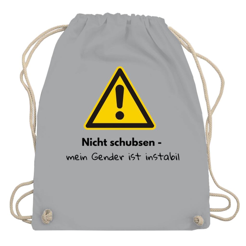 Gymbag mit großem gelben Warnzeichen mit Text „Nicht schubsen – mein Gender ist instabil“ auf dem Rücken